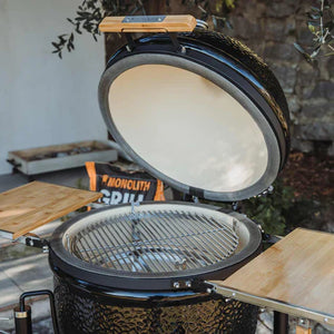 Monolith ONE premium kamado grill with open lid and bamboo side shelves.