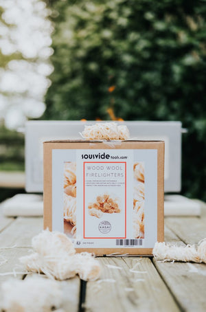 Eco-friendly Kasai Wood Wool Firelighters - 200pcs box with firelighters scattered, ideal for fireplaces and BBQs.