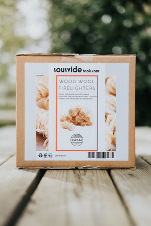 Kasai Wood Wool Firelighters - 200pcs box displayed outdoors, perfect for BBQs, camping, and sustainable fire starting solutions.