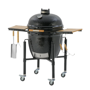 Monolith ONE.66 Ceramic Grill with closed lid, side tables extended, and BBQ tools hanging from hooks, ideal for premium outdoor grilling.