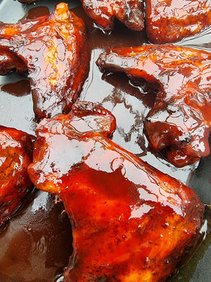 Grilled chicken coated in Firefly Competition Cherry BBQ Sauce, highlighting its thick, glossy finish and deep cherry glaze.