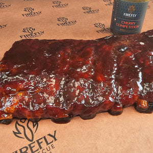 Cooked USDA St Louis Ribs glazed with Firefly Cherry Competition BBQ sauce, highlighting juicy texture and rich flavor.