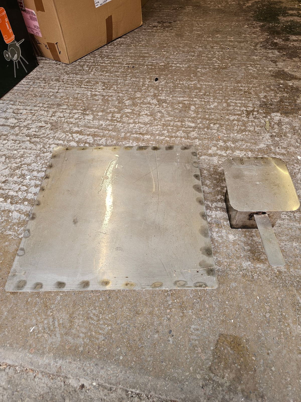 Metal smoker part on cardboard box in storage
