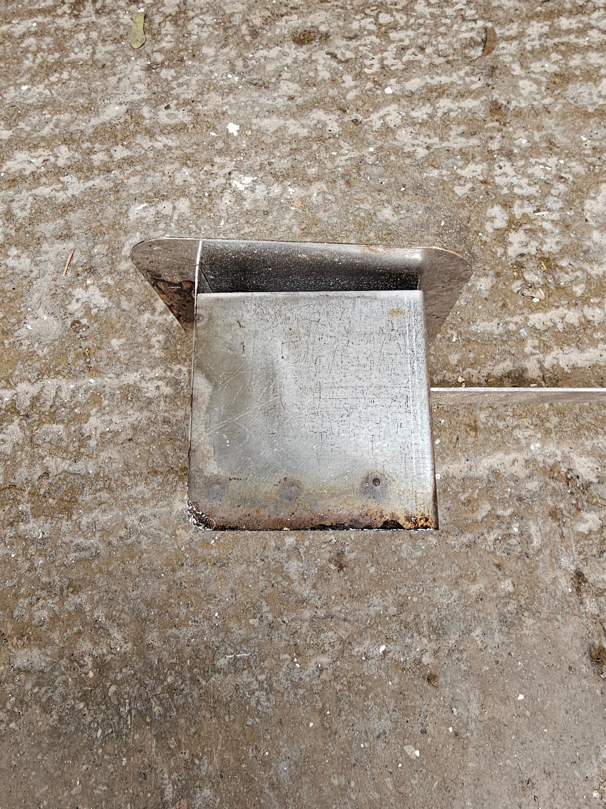 Metal corner bracket on rough concrete floor