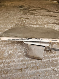 Close-up of metal smoker part on concrete floor