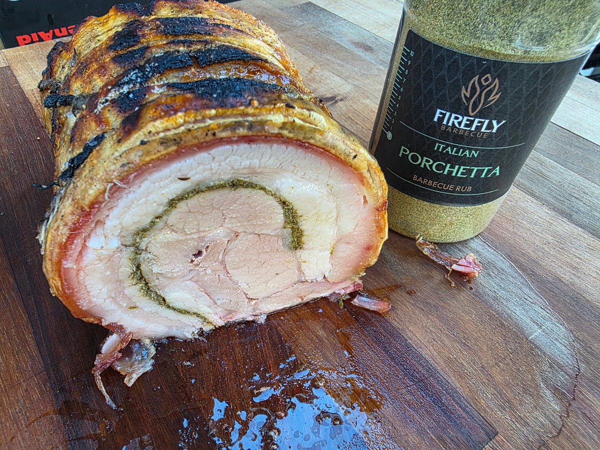 Cooked pork roast with herbs and spices on a wooden board