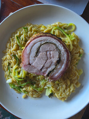 Grilled pork roast with herbs and spices on a wooden board