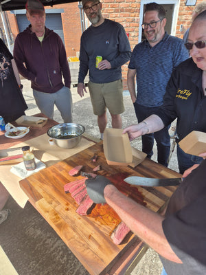 Group of people at outdoor BBQ event with food and drinks