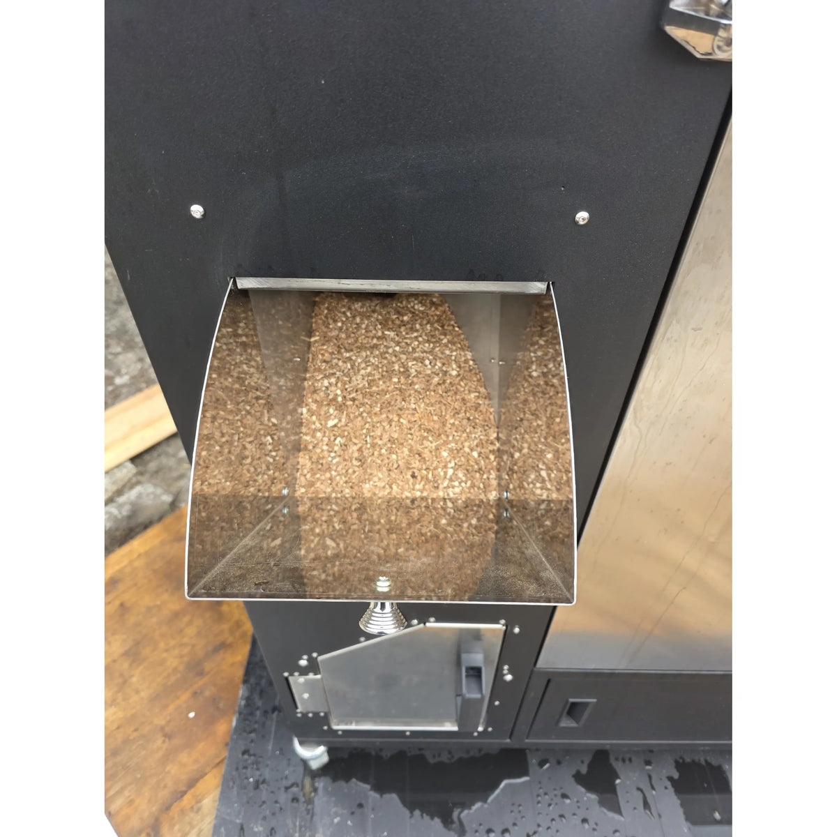 Black exterior of a commercial smoker with silver screws