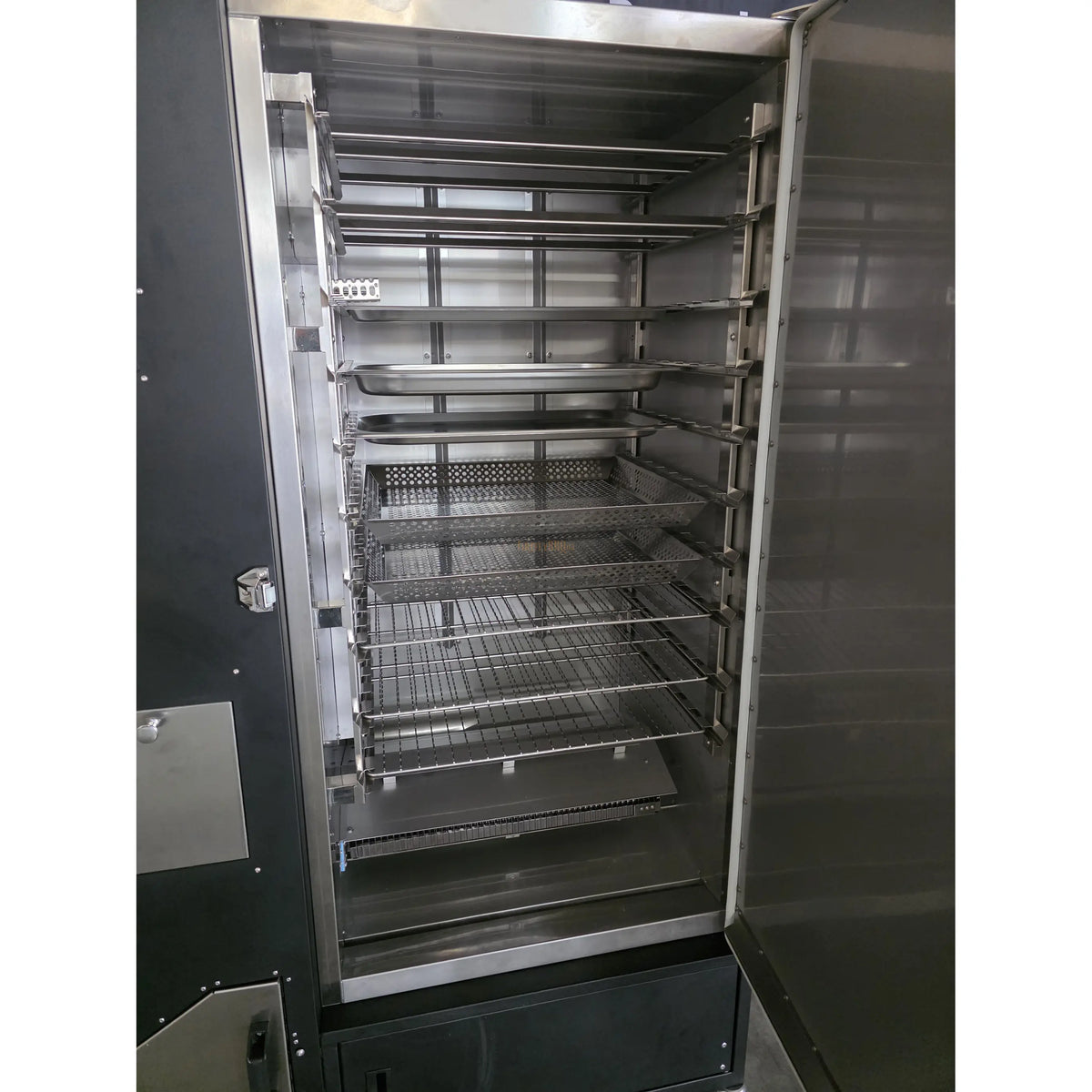 Open interior view of stainless steel food smoker with multiple racks