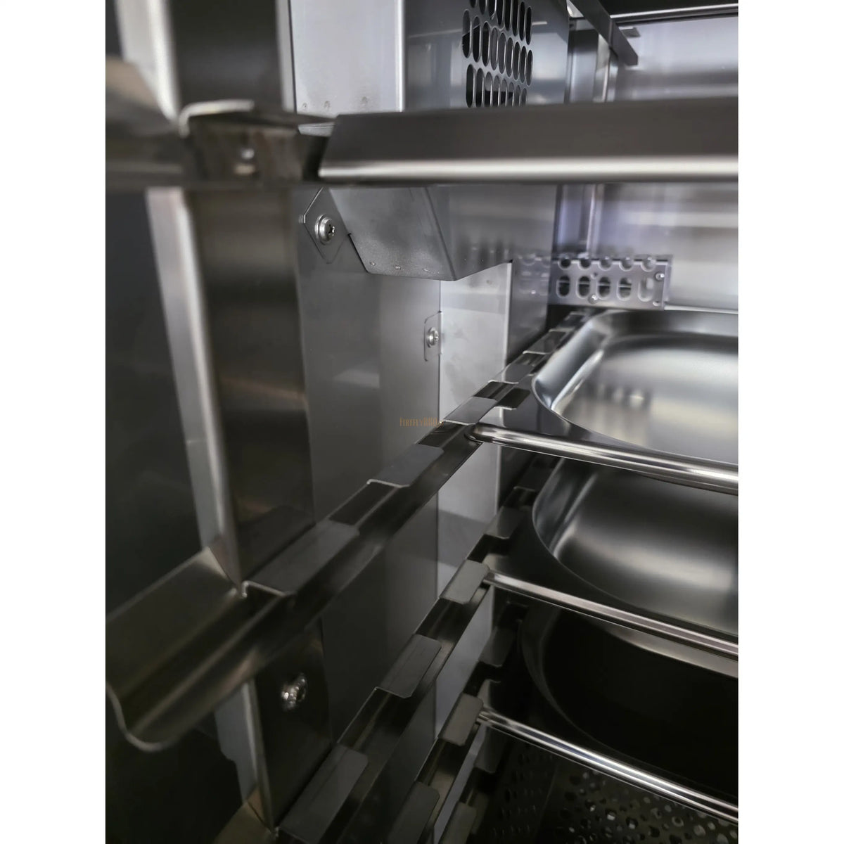 Side view of stainless steel smoker showing internal racks and ventilation