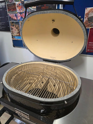 Open Primo Kamado Charcoal Grill with stainless steel grates and ceramic interior, ready for outdoor cooking use.