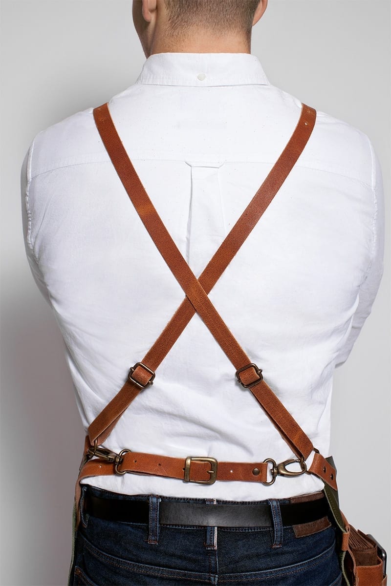 Leather cross-strap apron on man in white shirt for kitchen or BBQ use