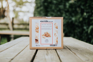 Front view of Kasai Wood Wool Firelighters - 200pcs box on wooden table, designed for clean and easy fire lighting in fireplaces or stoves.