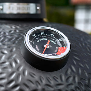 Monolith Avantgarde Kamado grill with built-in temperature gauge on textured black lid