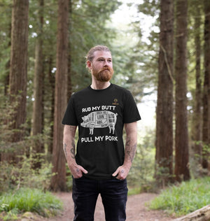 Man wearing Mens Rub my Butt T-Shirt with humorous pig cut diagram and BBQ slogan, ideal for outdoor grilling and casual wear.