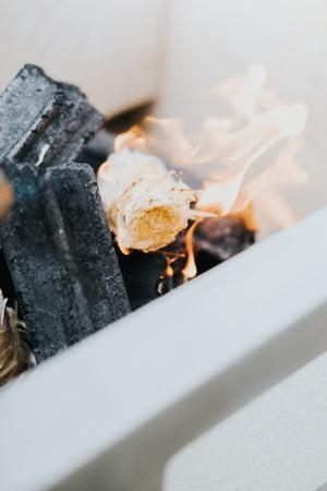 Kasai Wood Wool Firelighter igniting among charcoal, demonstrating fast and clean fire starting performance for outdoor use.