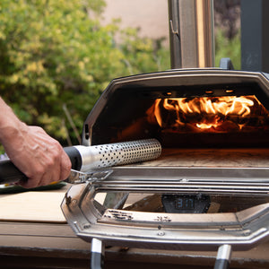 Looftlighter Electric Grill & Fire Starter being used to ignite wood in a pizza oven, ideal for home and garden cooking setups.