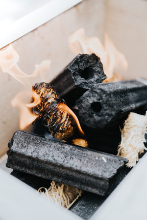 Kasai Wood Wool Firelighter burning with charcoal in a fire pit, emphasizing clean and sustainable fire lighting.