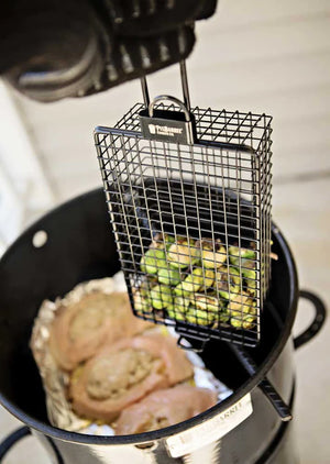 Pit Barrel All-Purpose Basket Hanger - FireFly Barbecue accessory holding vegetables inside a Pit Barrel Cooker alongside meat for simultaneous cooking.