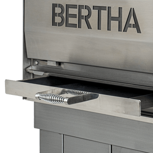 Ash drawer of Bertha X Charcoal Oven pulled out, designed for easy cleaning and maintenance in outdoor grilling setups.