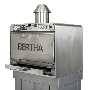 Side angle of Bertha X Charcoal Oven for efficient cooking, featuring chimney vent and robust stainless steel construction.