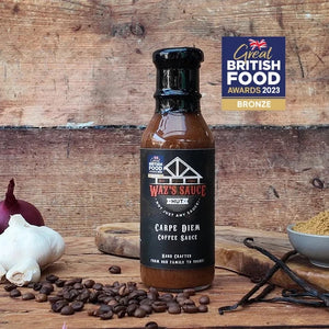 Carpe Diem Coffee Sauce bottle with black label and black cap, surrounded by garlic and coffee beans