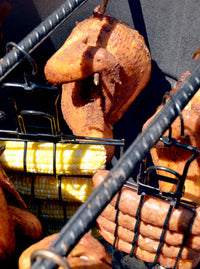Pit Barrel Sausage, Hot Dog & Brat Hanger - FireFly Barbecue in use with sausages, corn, and chicken smoking inside a Pit Barrel Cooker.