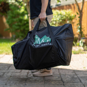 GMG Davy Crockett Tote Bag - FireFly Barbecue, person carrying durable black tote with GMG logo, ideal for grill transport on patios or camping trips.