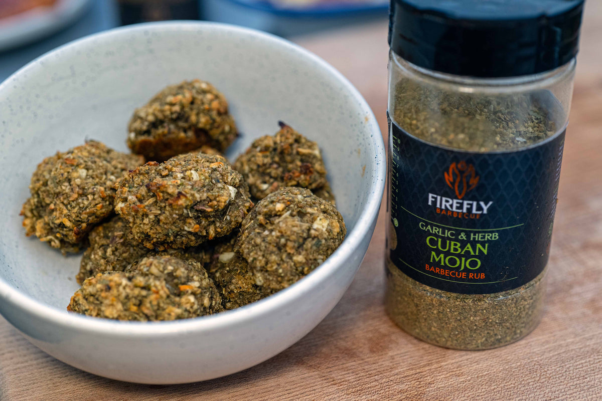 Cuban Mojo BBQ rub from BBQ Herby Legend gift set next to a bowl of seasoned meatballs, showcasing its flavorful use.