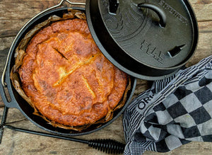 Petromax 3.5L Cast Iron Dutch Oven filled with baked dish, showcasing its use for rustic outdoor and indoor cooking.