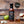 Wooden table with apples, garlic, and a jar of sauce