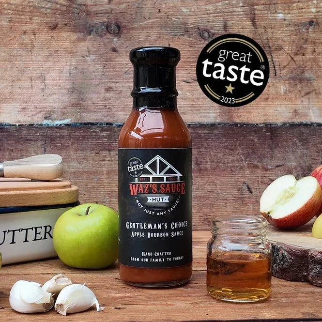 Wooden table with apples, garlic, and a jar of sauce