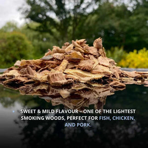 Pile of chopped wood chips outdoors with blurred green trees in background