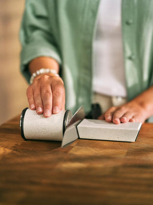 Person using HORL 3 Cruise Knife Sharpener with 15° angle block on a kitchen knife, demonstrating ergonomic and precise sharpening.