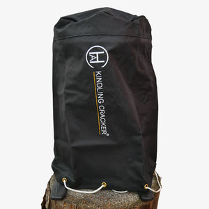 Black Kindling Cracker Cover on tree stump, featuring reinforced eyelets and drawstring for secure, weather-resistant tool organization.
