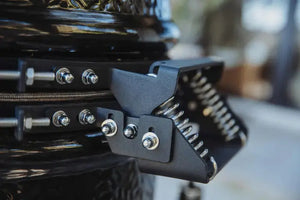 Close-up of Monolith ONE 55 hinge mechanism with heavy-duty spring system for smooth lid operation, part of FireFly Barbecue's grill range.