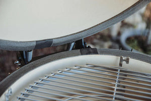 Detail of Monolith ONE.66 ceramic grill lid with high-quality glass fiber seal and stainless steel grate for optimal BBQ heat retention.