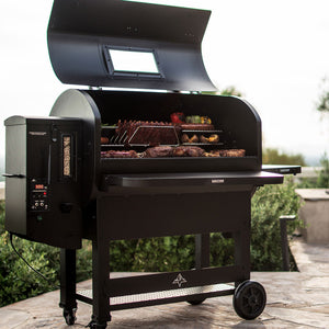 Full view of GMG Trek Cart with GMG Prime 2.0 RACKT Backboard, showcasing loaded grill with meats and veggies on multiple stainless steel racks.