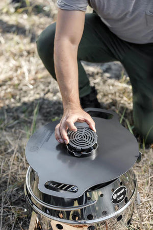 Person placing Petromax insert on Atago griddle, outdoor cooking