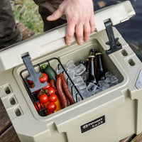 Person placing Petromax dry rack basket in cool box with food and drinks