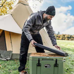 Man using Petromax Adhesive Pad for 50L Cool Box - Dragon outdoors, showcasing its utility for camping and food storage.