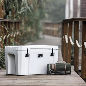 Petromax 75L Cool Box placed on a wooden path with a blanket, ideal for picnics, camping, and garden gatherings.