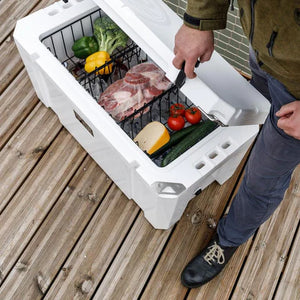 Petromax 75L Cool Box filled with vegetables, cheese, and meat, demonstrating its large capacity for outdoor food storage.