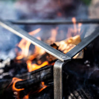 Cooking stand over campfire flames