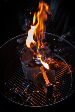 Pit Barrel Chimney Starter with glowing coals and flames on grill, perfect for set-it-and-forget-it barbecue cooking setups.