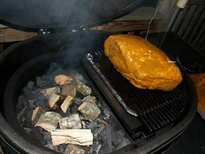 Primo grill with heat deflector and smoked meat for indirect cooking