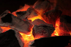 Glowing Big K Chilla-Grilla charcoal briquettes burning with consistent heat, perfect for 3-4 hour BBQ cooking sessions with sustainable fuel.