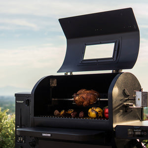 GMG Trek Cart featuring GMG Prime 2.0 RACKT Backboard grilling whole chicken and vegetables with rotisserie setup and stainless steel accessories.
