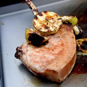 Grilled pork chop and vegetables on the Kasai Konro Plancha Solid grill plate. Ideal for searing meats on small Konro grills.